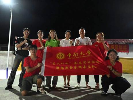 图十三:活动结束后塔卧镇副镇长谭佳勋等政府干部与队员们的合影